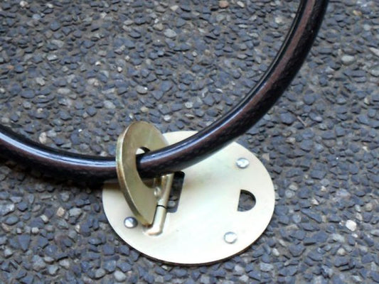Anchor-Loop security anchor attached to pavement with bolts with a bike cable through it
