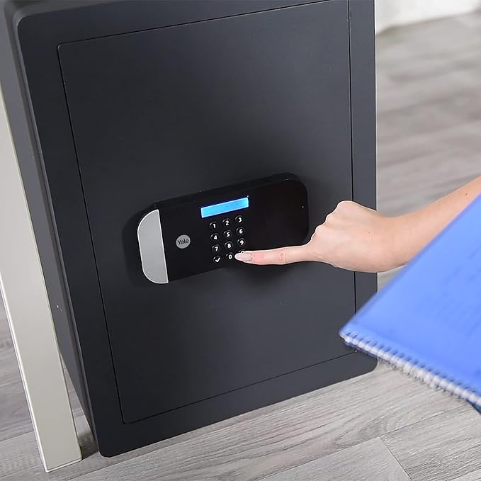 Person using a digital keypad on a black safe box.