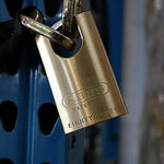 close up of an Abus brass closed shackle padlock attached to a chain