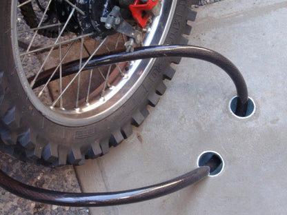 Anka-U in ground security anchor concreted into ground with a cable holding a motorcycle in place