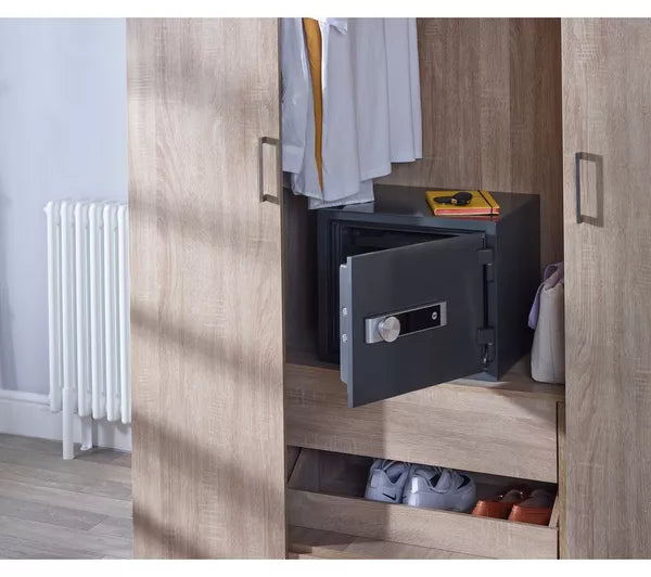 Open safe in a wooden wardrobe with clothes and shoes visible
