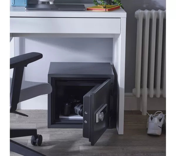 Open safe underneath a desk in an office setting