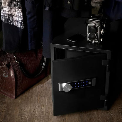 Black safe on a wooden floor with a handbag and vintage camera in the background