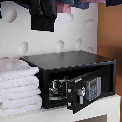 Black safe box on a white shelf with towels and clothes in the background